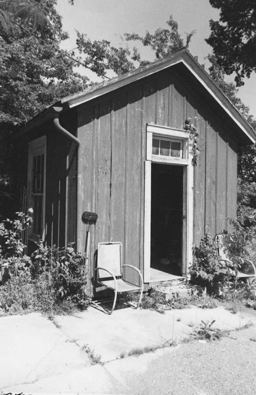 Pair of chairs outside small building with open door
