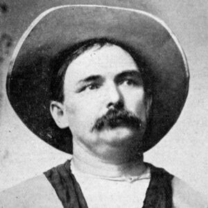 White man with a large mustache in a wide brimmed hat