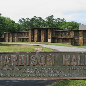 Multistory stone brick building with circular driveway and "Hardison Hall" plaque in the foreground