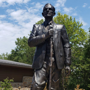Statue of man with glasses in suit holding a walking stick