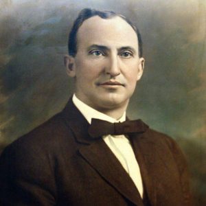 White man in brown suit and bow tie