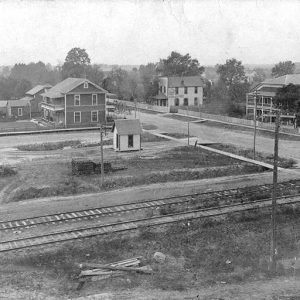 Multistory buildings on town streets with railroad tracks in the foreground
