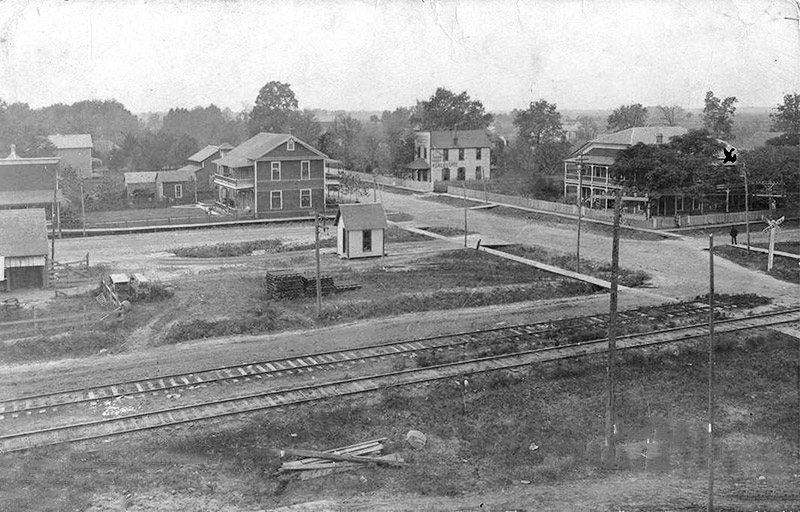 Multistory buildings on town streets with railroad tracks in the foreground