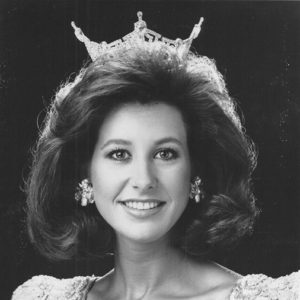 Young white woman smiling with long hair and tiara