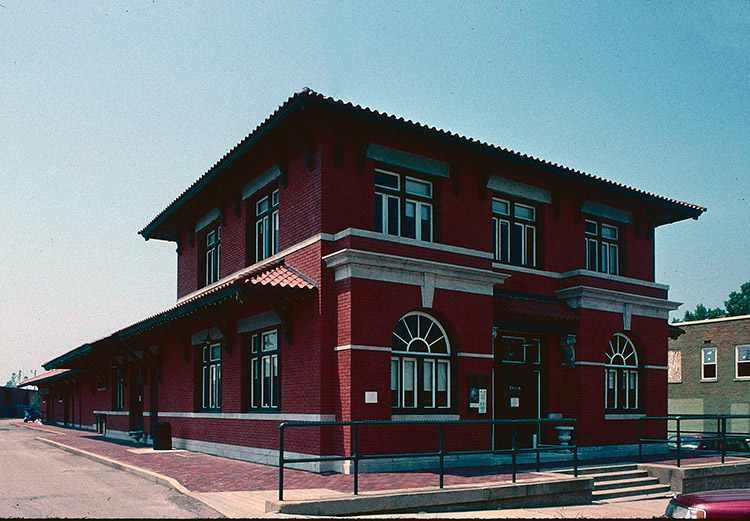 Two-story brick railroad depot building with arched windows
