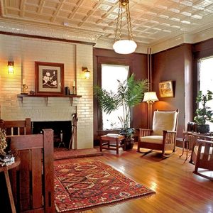 Interior room with wood floor fireplace and tiled ceiling with wood furniture and covered windows