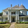 Two-story house with gazebo and four porch columns and round tower with covered porch