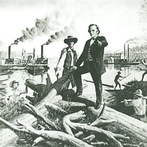 White man with hat and vest standing amid uprooted tree trunks next to another white man in suit with steamboats behind them