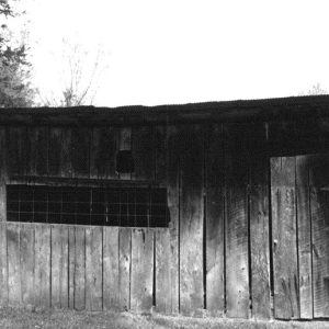 Wooden shed building with screen window on farm