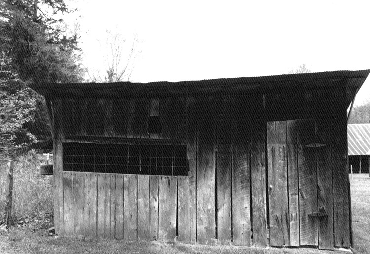 Wooden shed building with screen window on farm