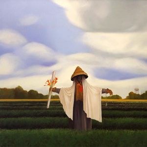 Scarecrow with conical hat and robes in green field with water tower and trees in the background