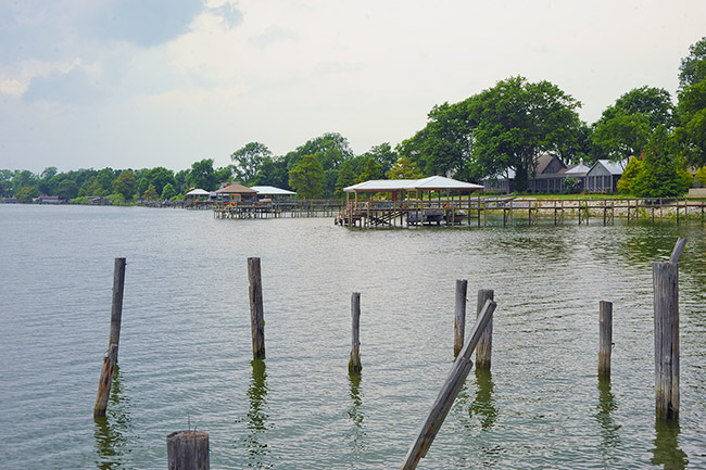 Row of boat docks on lake with house