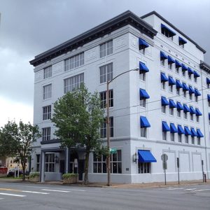 Five-story building with blue window awnings on street corner