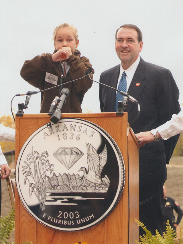 Portrait of white man in suit and tie and young white girl at lectern