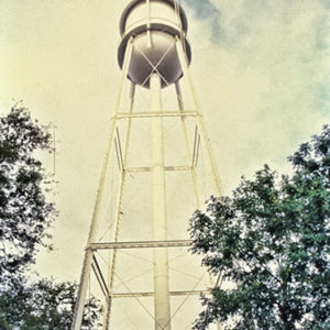 Looking up at water tower with pavilion and trees beneath it
