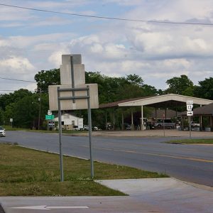 Service station with Shell sign and large canopy on two-lane road