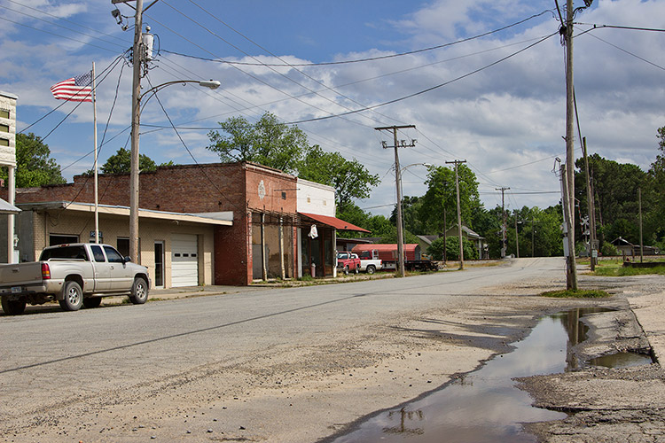 Brick storefronts and power lines on rural road