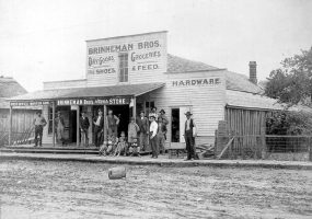 Group of people posing outside "Brinneman Bros Dry Goods Groceries Fine Shoes and Feed Hunter Arkansas"