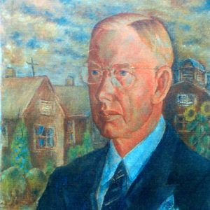 White man in suit and tie with buildings behind him
