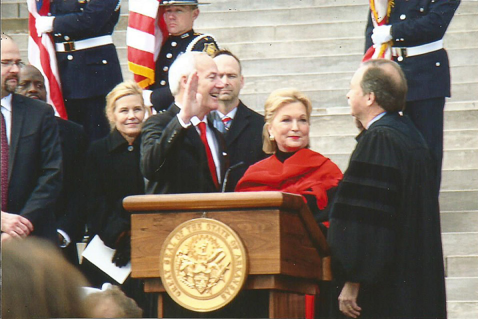 Mixed crowd of officials including one in judge's robes on steps of capital during inauguration ceremony