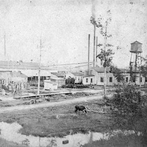 Single-story buildings and water tower at lumber facility