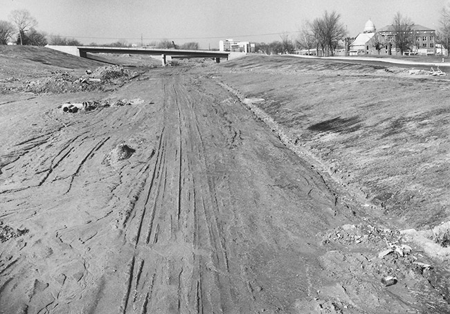Pre-pavement highway with concrete bridge in the background