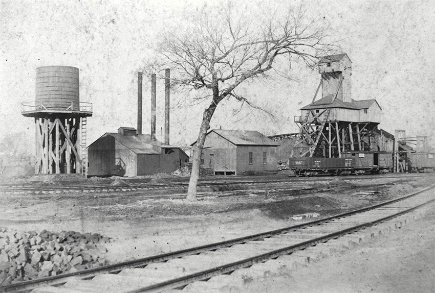 Factory buildings with water tower and railroad tracks