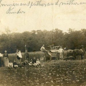 Group of white men women and children with horse drawn wagon in field
