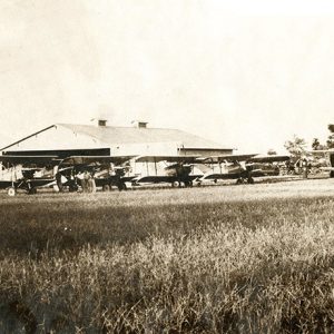 Line of biplanes and hangers at air field