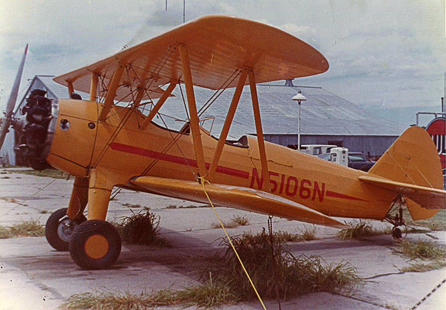 Yellow biplane with orange stripe and lettering