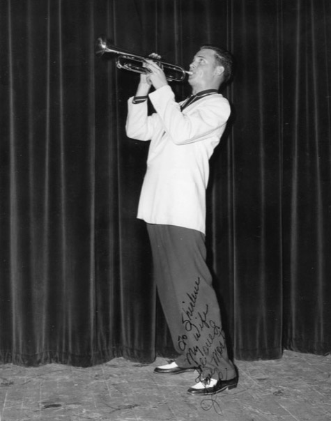 signed photo of young white man in white suit jacket playing trumpet