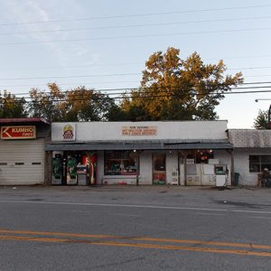 Single-story storefronts and garage building on two-lane street