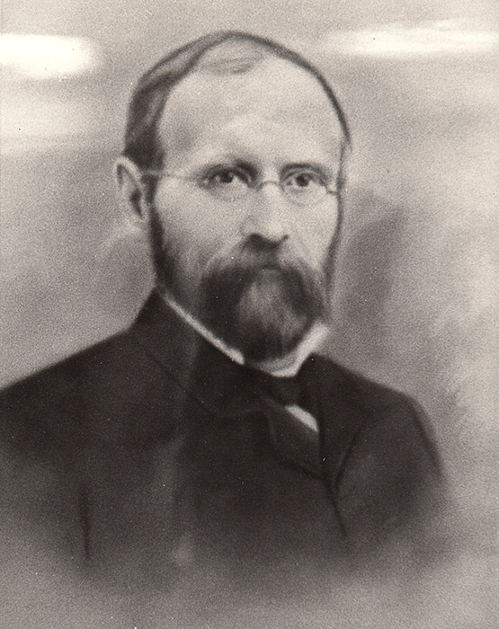 White man with beard and glasses in suit with bow tie