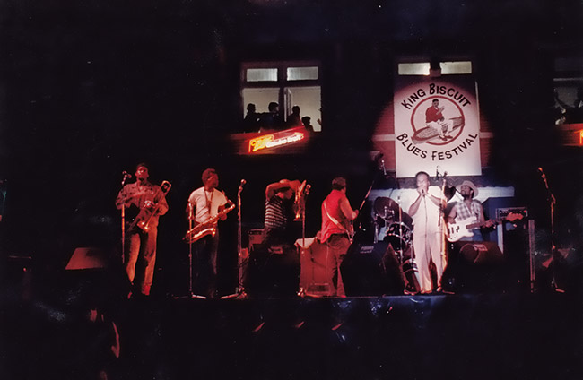 African-American guitar and brass band on stage
