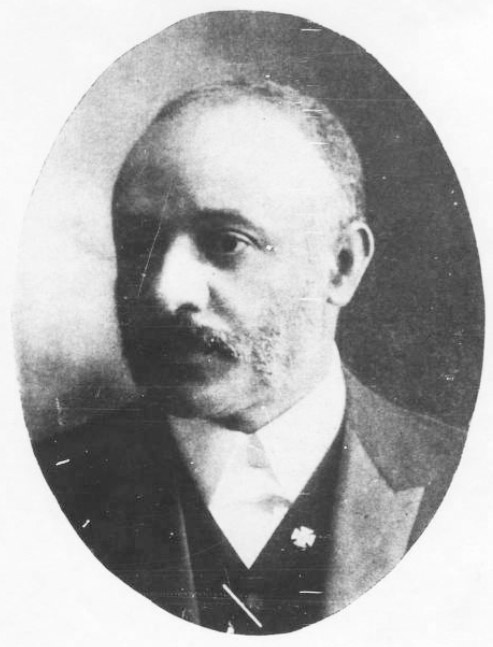 African-American man in suit with Maltese cross lapel pin