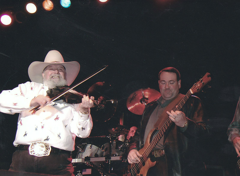 Two white men playing violin and bass on stage