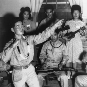 Asian American men and women dancing and playing instruments