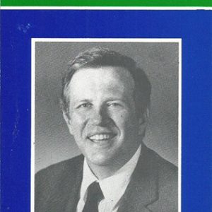 White man smiling in suit on blue white and green brochure
