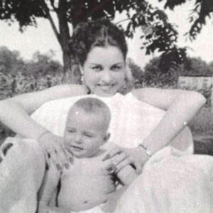 White woman and baby sitting under a tree