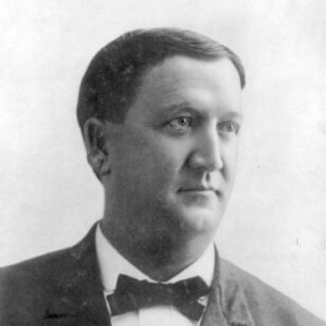 White man with brown hair in suit jacket and bow tie