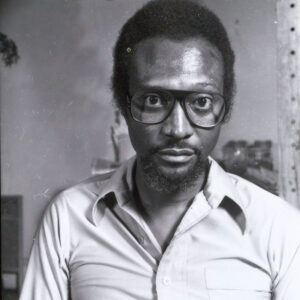 African-American man in glasses with beard and collared shirt