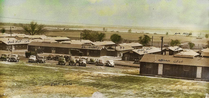 Single-story barracks with cars in parking lot