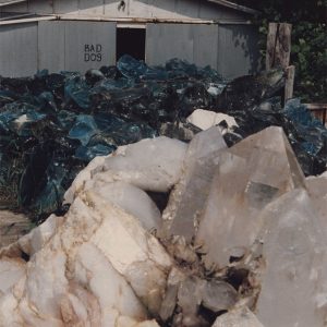 White and blue crystals on display in front of tin building with words "Bad dog"