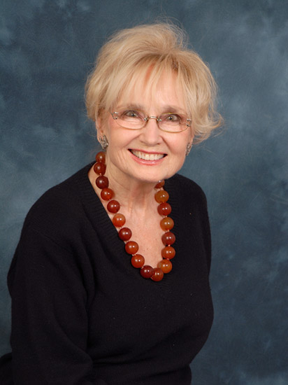 Old white woman in glasses wearing red beads around her neck