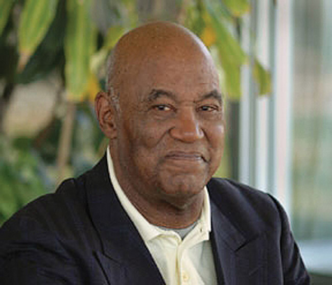 Older African-American man smiling in suit jacket and shirt
