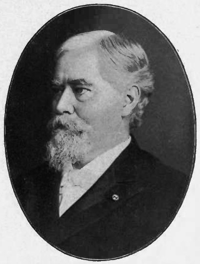 Profile view of white man with beard in suit