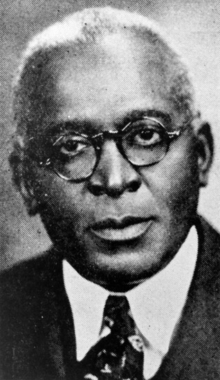 African-American man with round glasses in suit jacket and tie