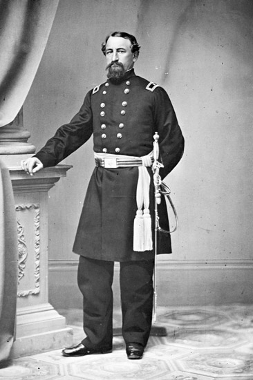 White man with beard posing in military uniform with sword