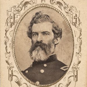 White man with curly hair and long beard in military uniform in oval frame