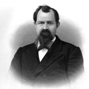 White man with dark beard in suit jacket and white shirt signed "as ever your friend John Crawford"